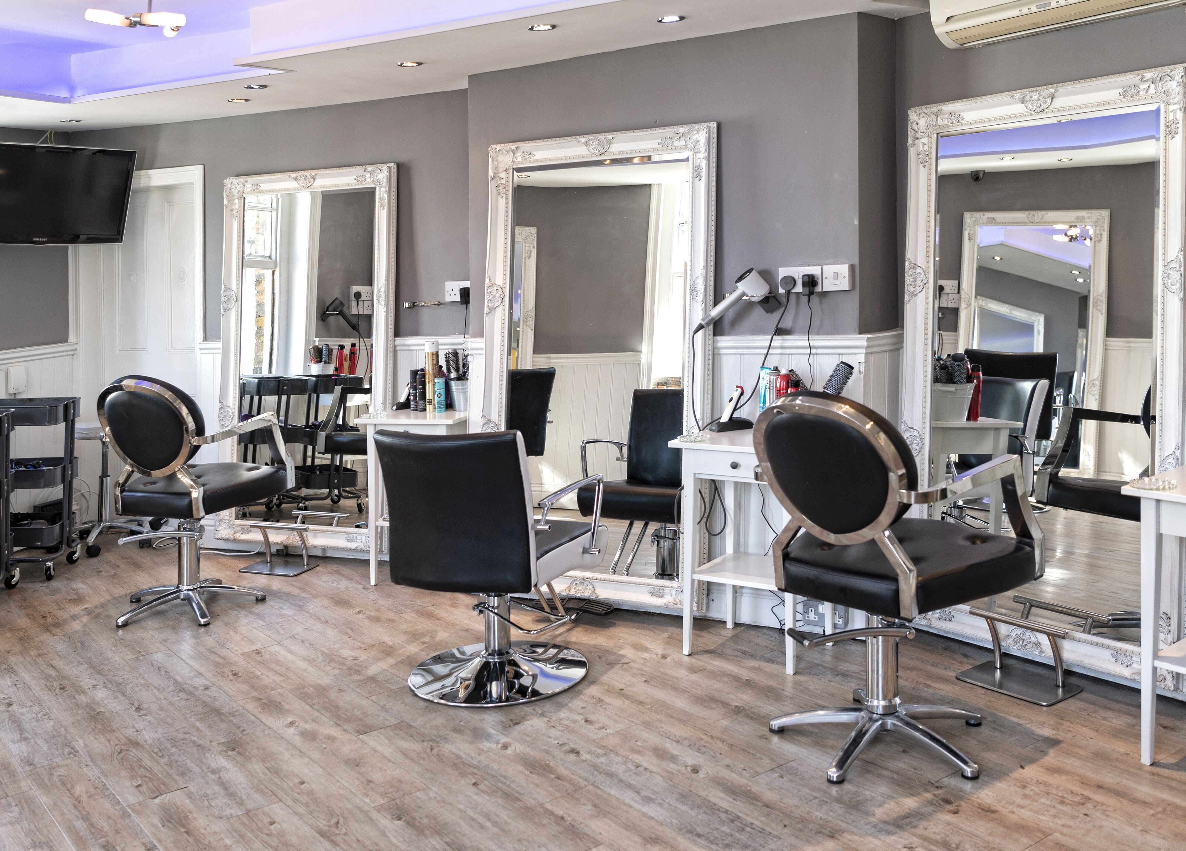 Modern hair styling stations at Studio 6 in Hertford, England, GB, featuring elegant mirrors and sleek chairs.