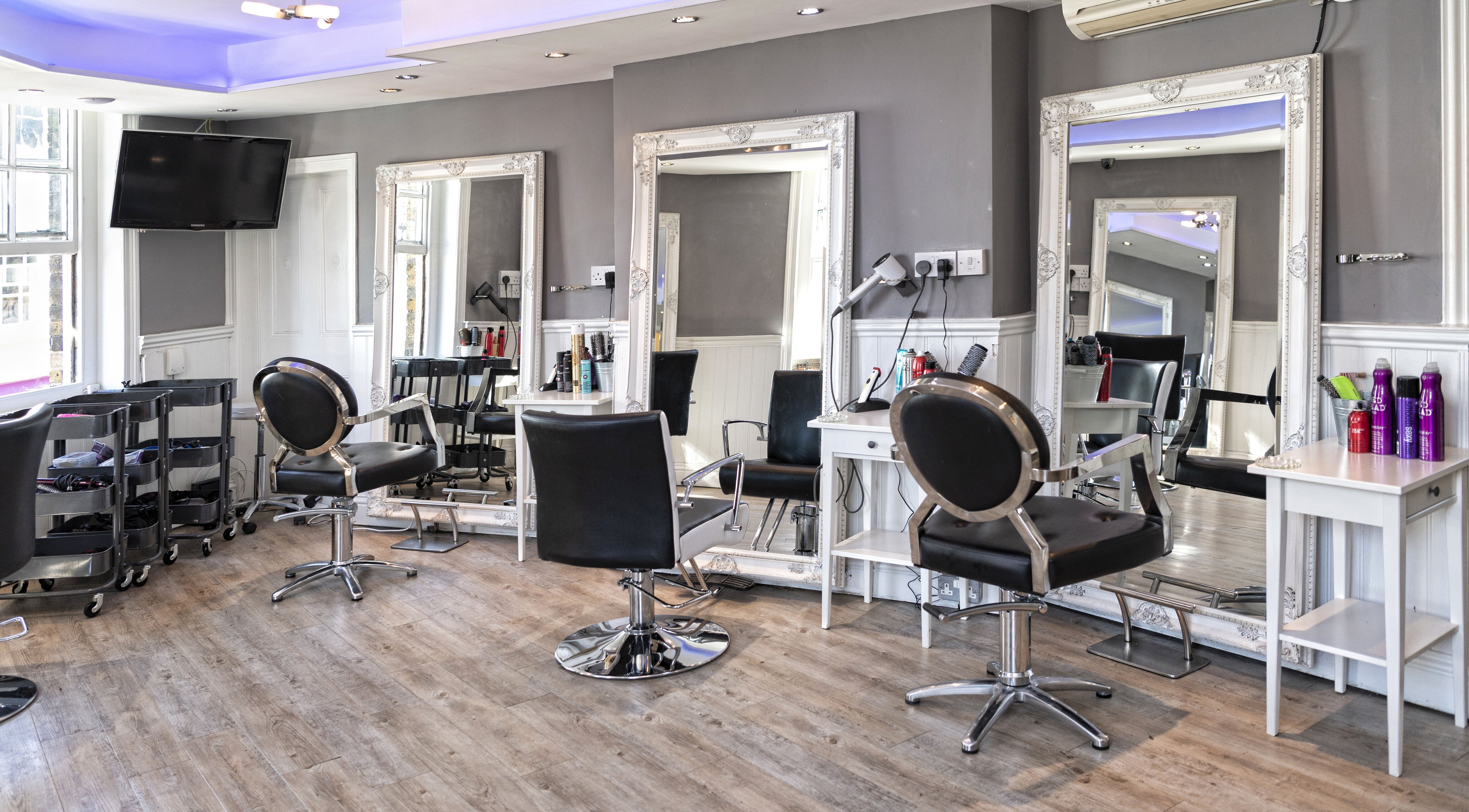 Modern hair styling stations at Studio 6 in Hertford, England, GB, featuring elegant mirrors and sleek chairs.