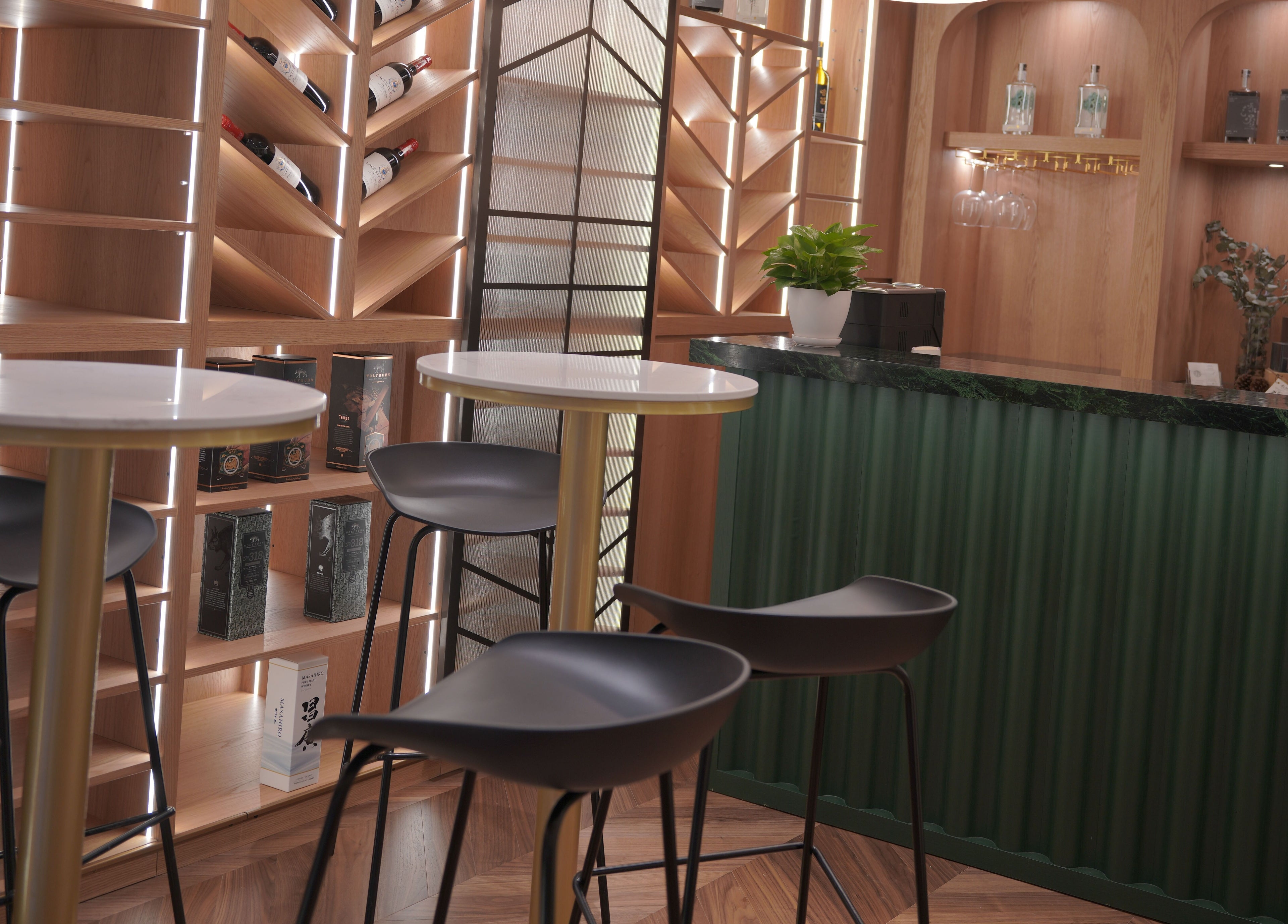 Modern bar area at Canton Barber Wan Chai, Hong Kong Island, HK with sleek chairs and illuminated shelves.