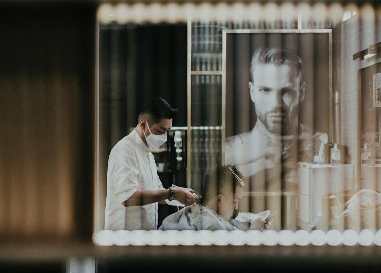 Barber giving haircut at Canton Barber Causeway Bay, Hong Kong Island, HK.