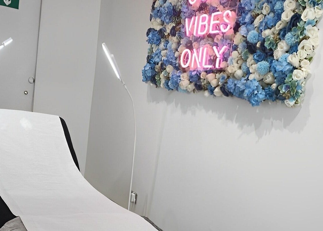 Cozy beauty room at Lucy Clydesdale Makeup Brows Lashes, Yarm, England, GB with floral decor and neon sign.