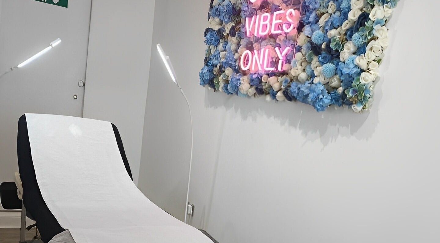 Cozy beauty room at Lucy Clydesdale Makeup Brows Lashes, Yarm, England, GB with floral decor and neon sign.