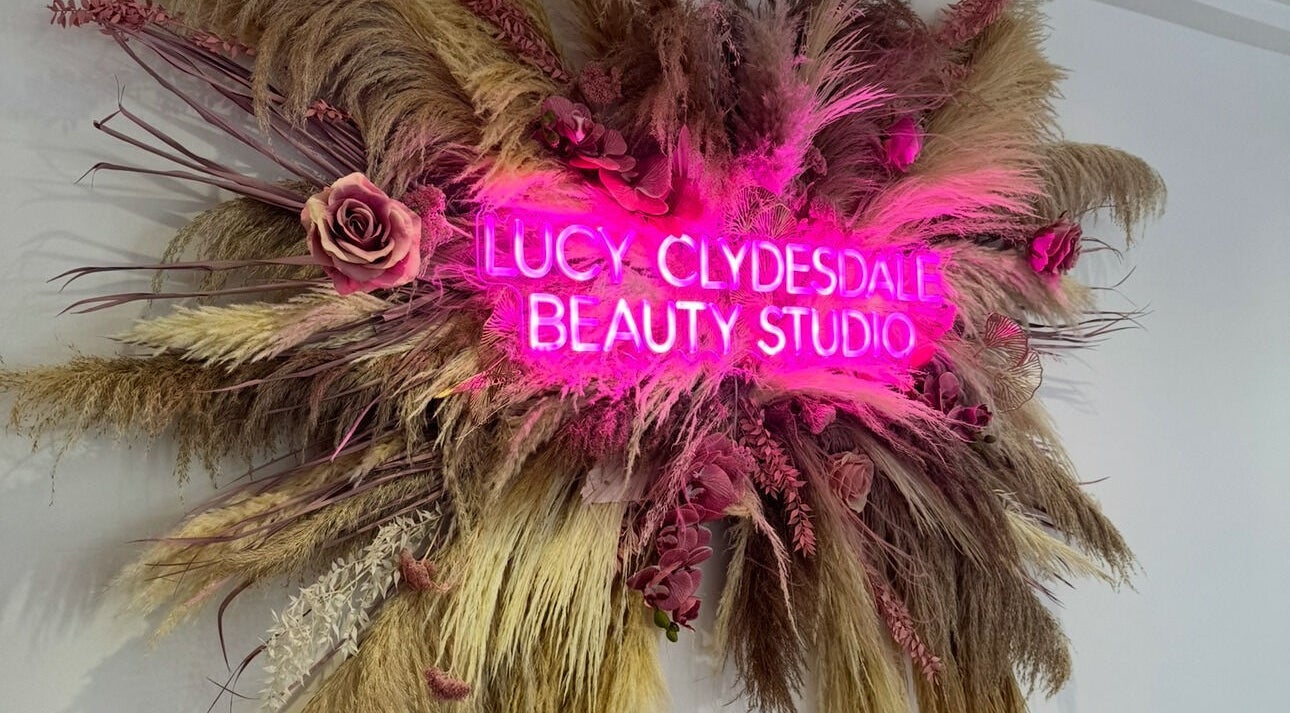 Bright neon sign with flowers at Lucy Clydesdale Makeup Brows Lashes, Yarm, England, GB.