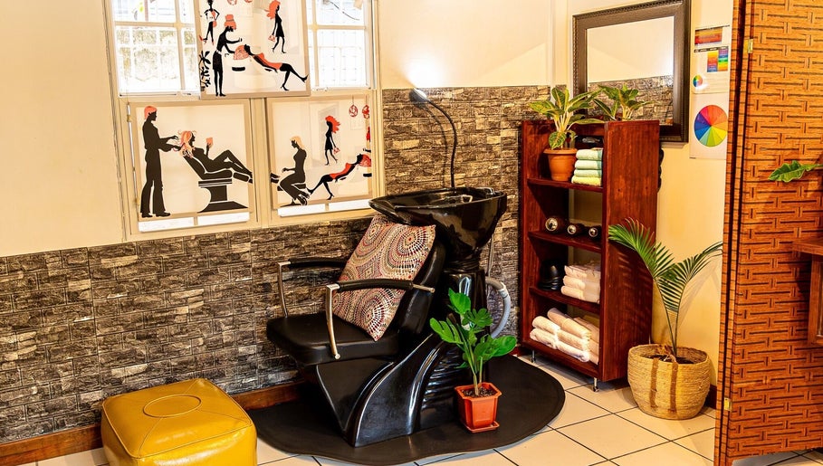 Stylish salon chair at Studio40, Port of Spain, TT, with artful wall designs and vibrant decor.