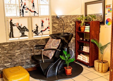 Stylish salon chair at Studio40, Port of Spain, TT, with artful wall designs and vibrant decor.