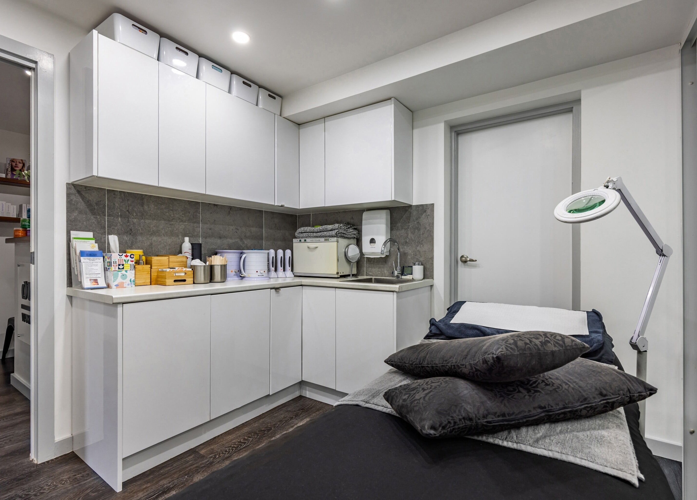 Modern treatment room at Ouch Waxing Studio, Bonnet Bay, New South Wales, AU, featuring sleek cabinetry and a massage bed.