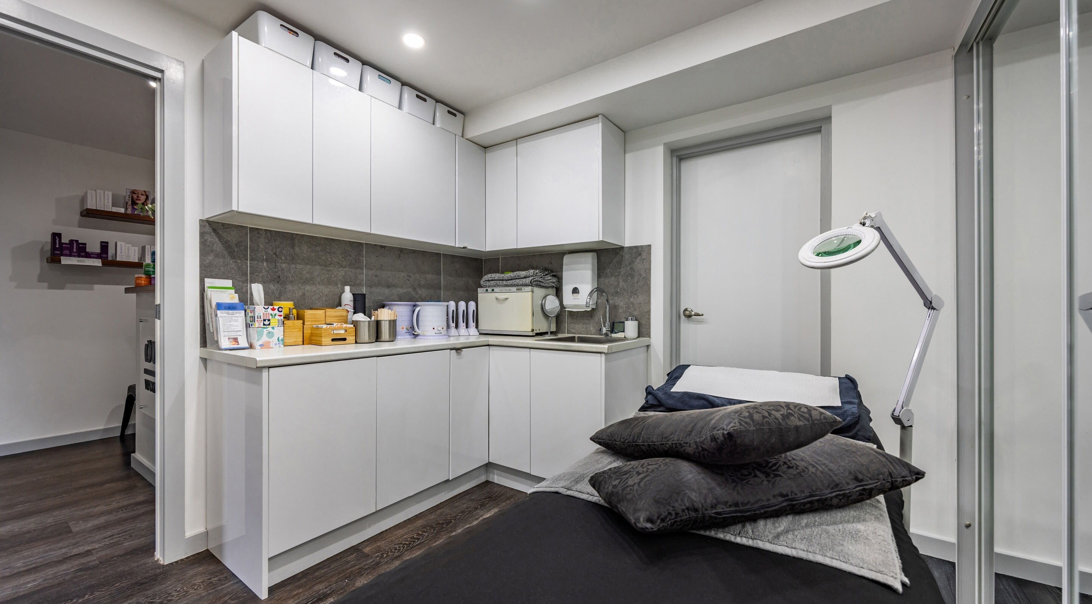 Modern treatment room at Ouch Waxing Studio, Bonnet Bay, New South Wales, AU, featuring sleek cabinetry and a massage bed.