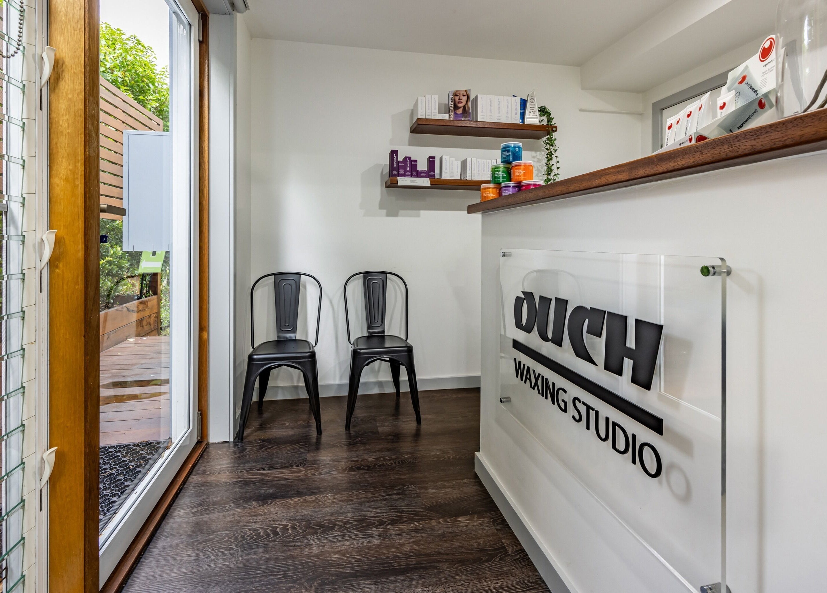 Modern entrance of Ouch Waxing Studio, Bonnet Bay, New South Wales, AU, with sleek decor and seating.