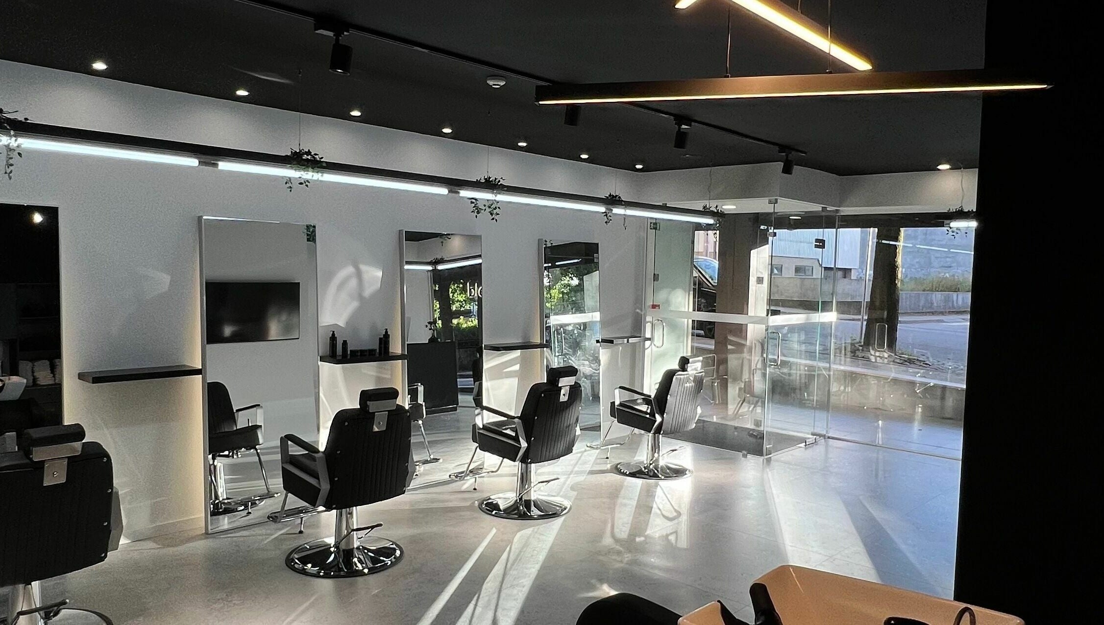 Interior elegante do Blend Men's Salon | Taipas, em Guimarães, PT, com design contemporâneo e cadeiras de barbeiro.