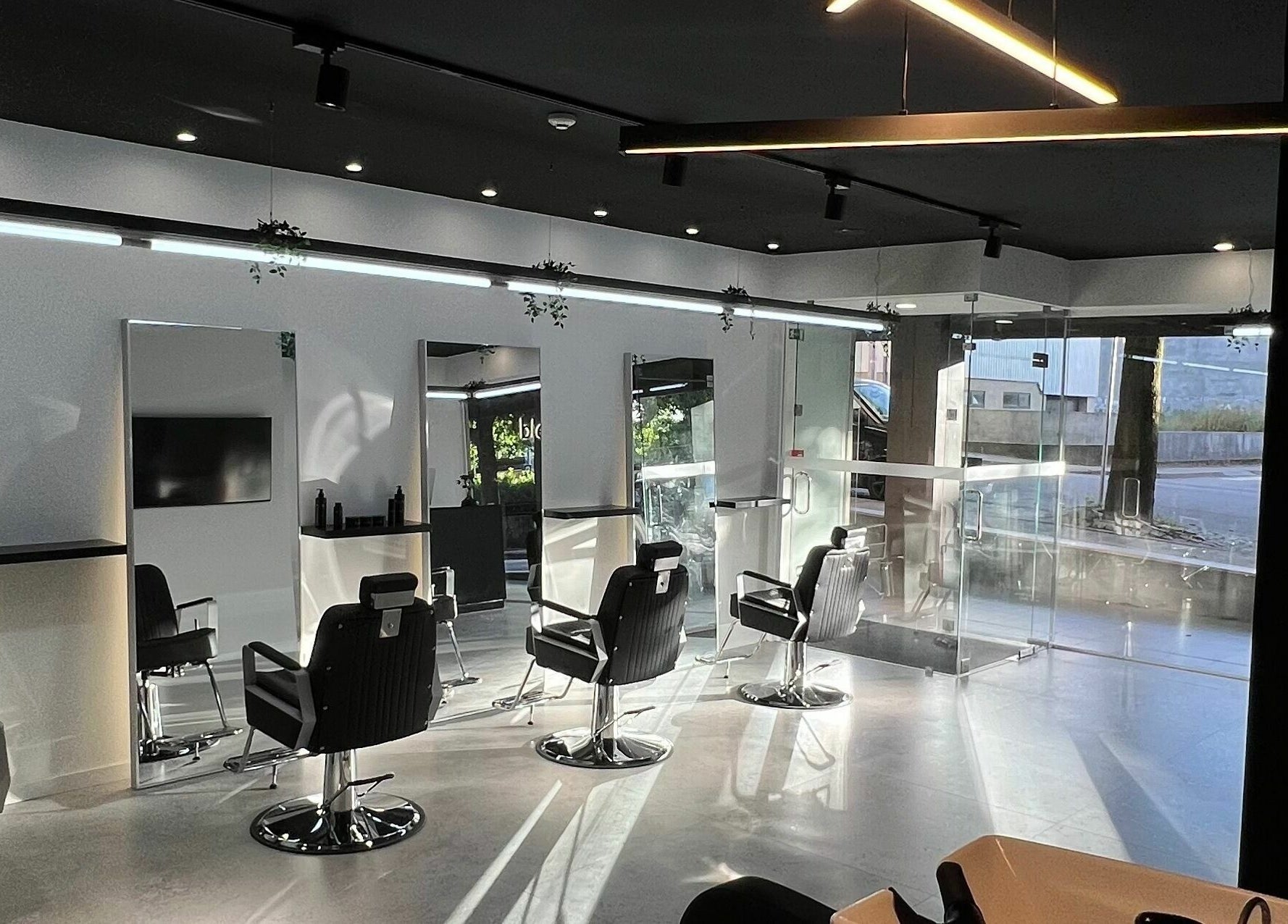 Interior elegante do Blend Men's Salon | Taipas, em Guimarães, PT, com design contemporâneo e cadeiras de barbeiro.