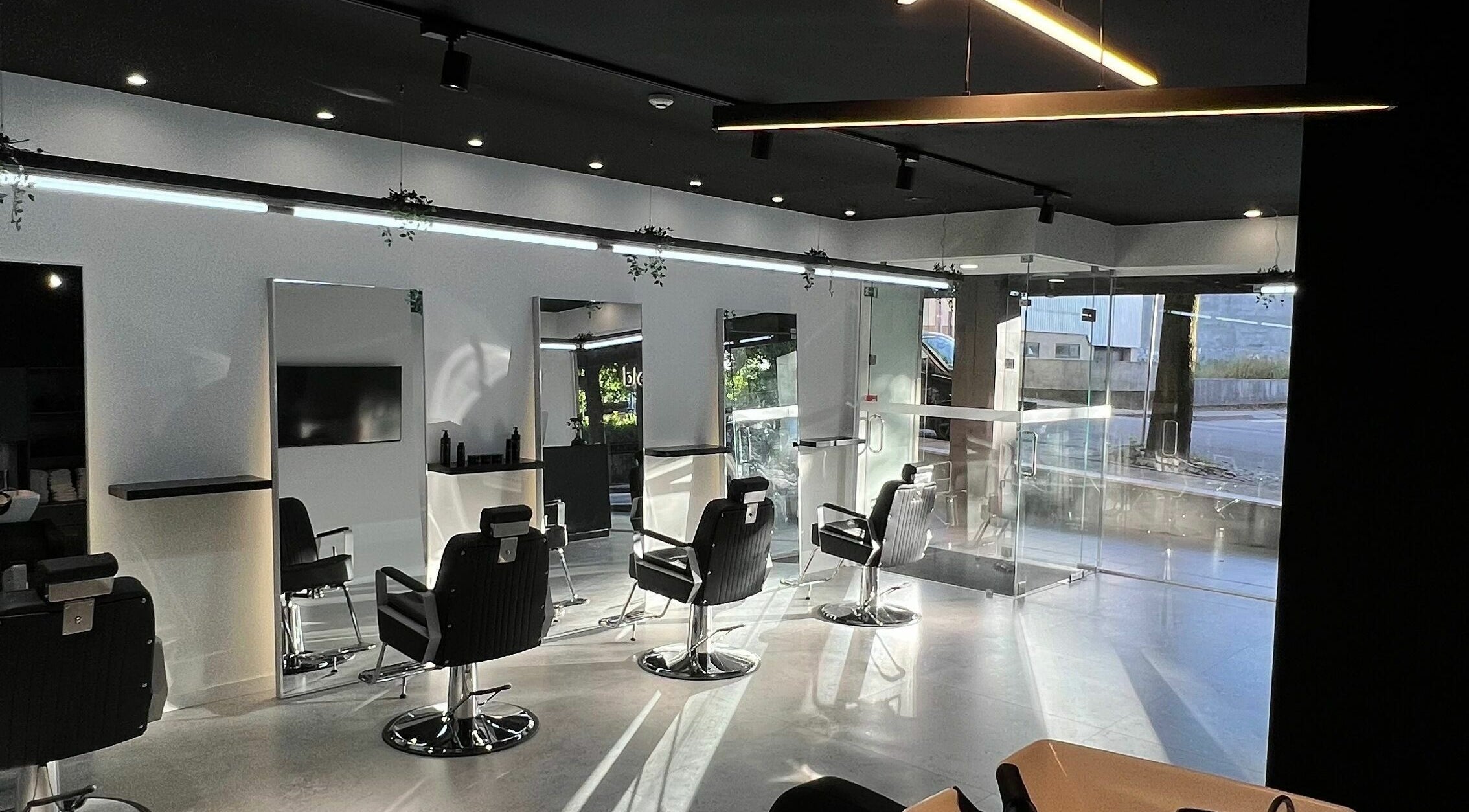 Interior elegante do Blend Men's Salon | Taipas, em Guimarães, PT, com design contemporâneo e cadeiras de barbeiro.