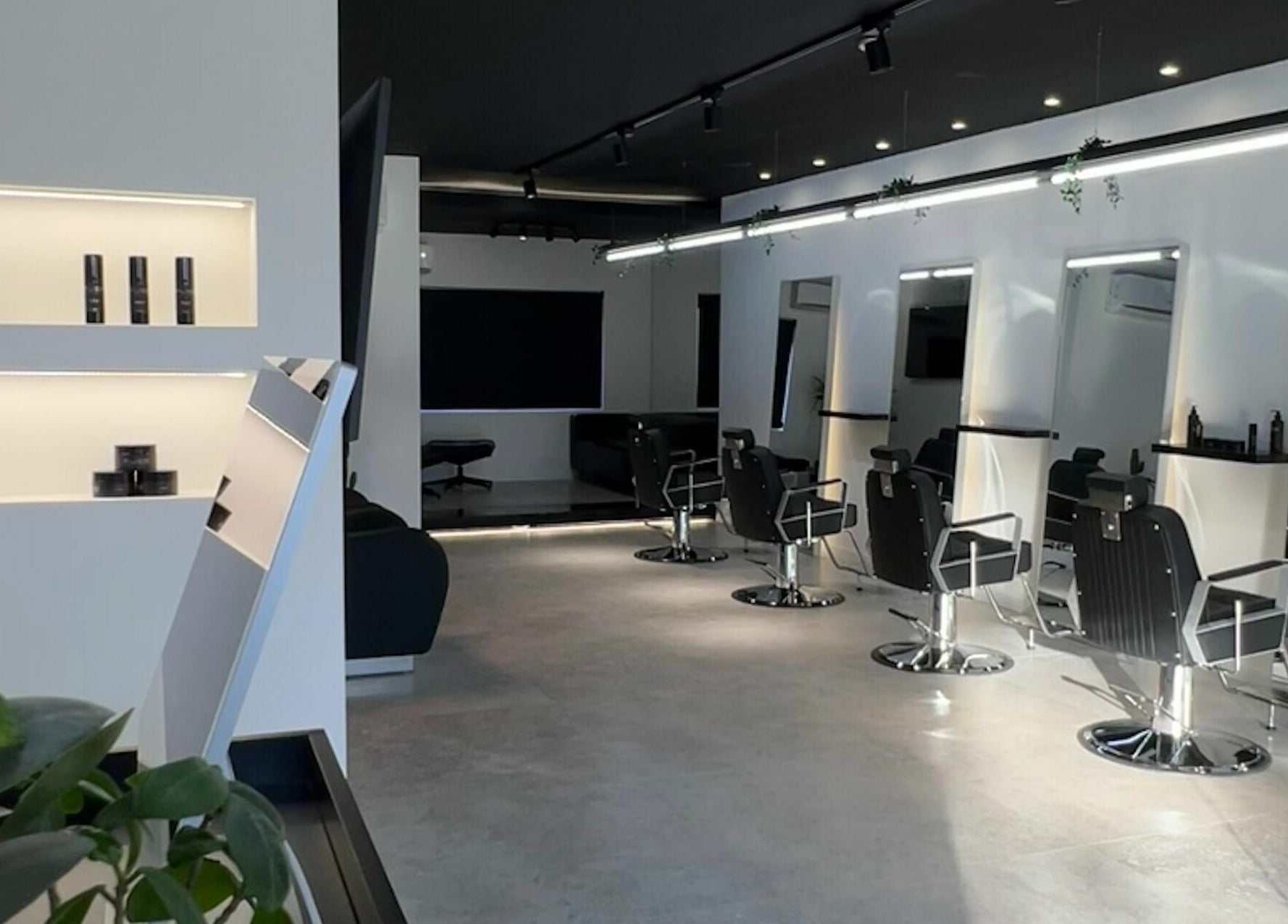 Interior moderno do Blend Men's Salon | Taipas em Guimarães, PT com cadeiras de barbeiro e decoração estilosa.