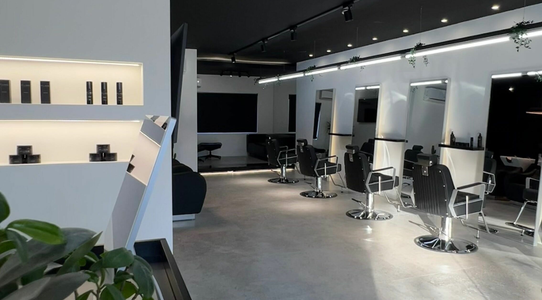 Interior moderno do Blend Men's Salon | Taipas em Guimarães, PT com cadeiras de barbeiro e decoração estilosa.