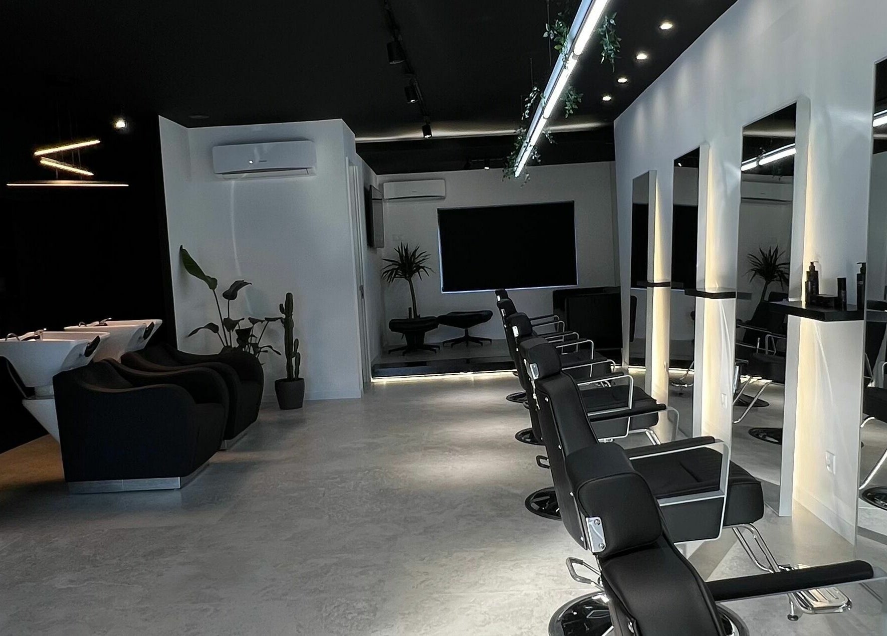 Interior moderno do Blend Men's Salon | Taipas em Guimarães, PT, com cadeiras de barbearia e estética elegante.