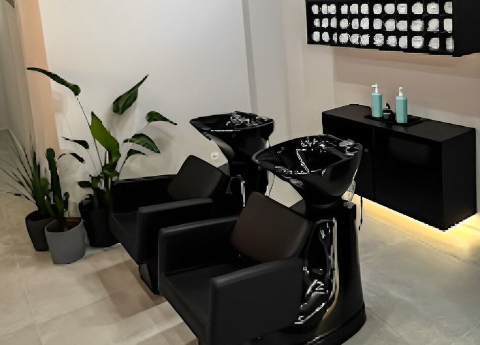 Salão elegante no Blend Men's Salon | Guimarães, com cadeiras pretas e planta decorativa. Localizado em Guimarães, PT.
