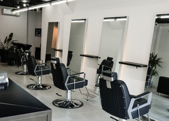 Interior sofisticado do Blend Men's Salon | Guimarães em Guimarães, PT, com cadeiras de barbear elegantes.