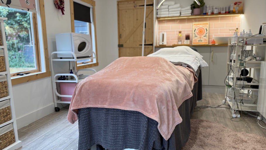 Relaxing treatment room at The Skin and Beauty Studio, Beaconsfield, England, GB with cozy blanket and soft lighting.