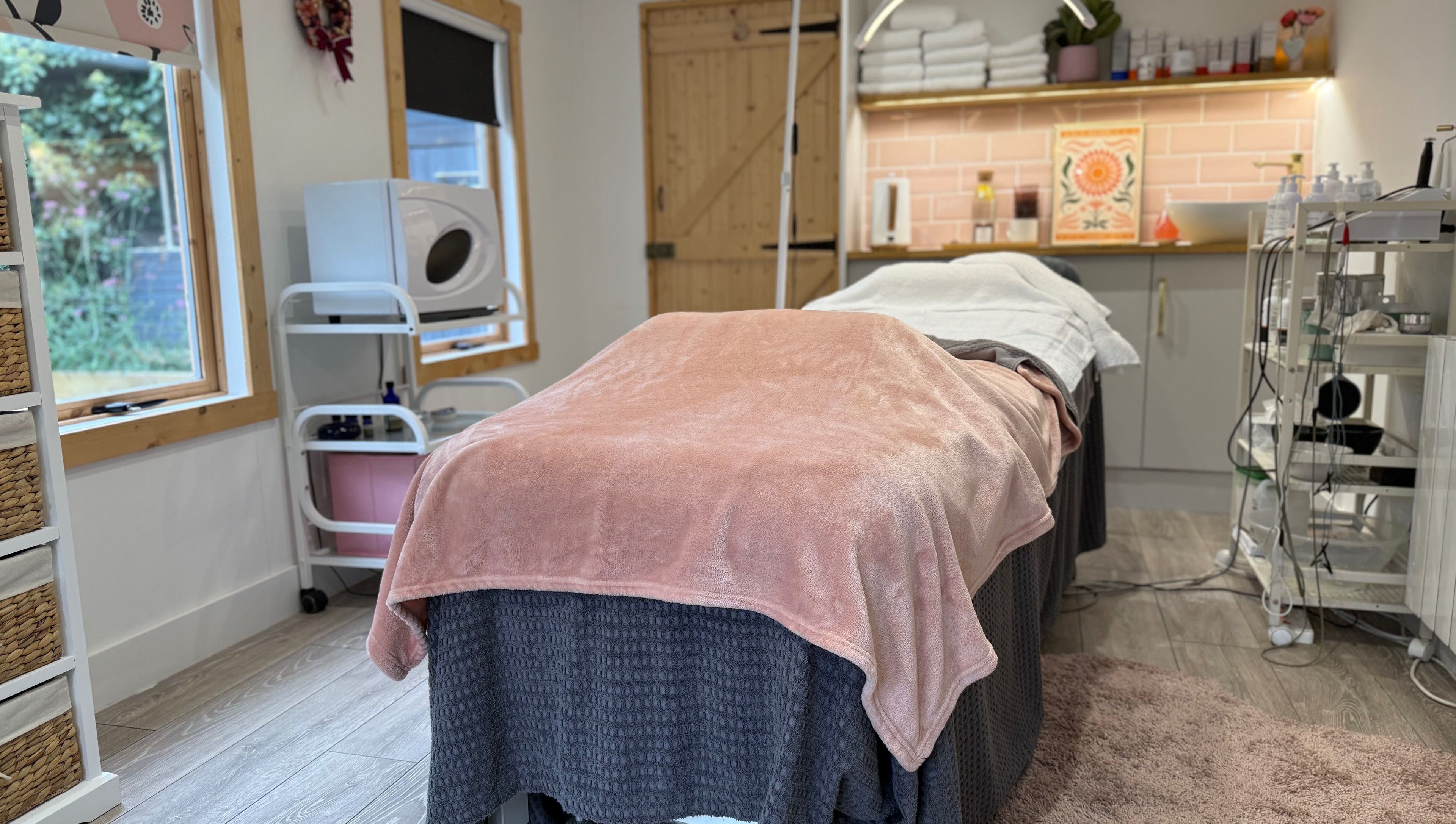 Relaxing treatment room at The Skin and Beauty Studio, Beaconsfield, England, GB with cozy blanket and soft lighting.