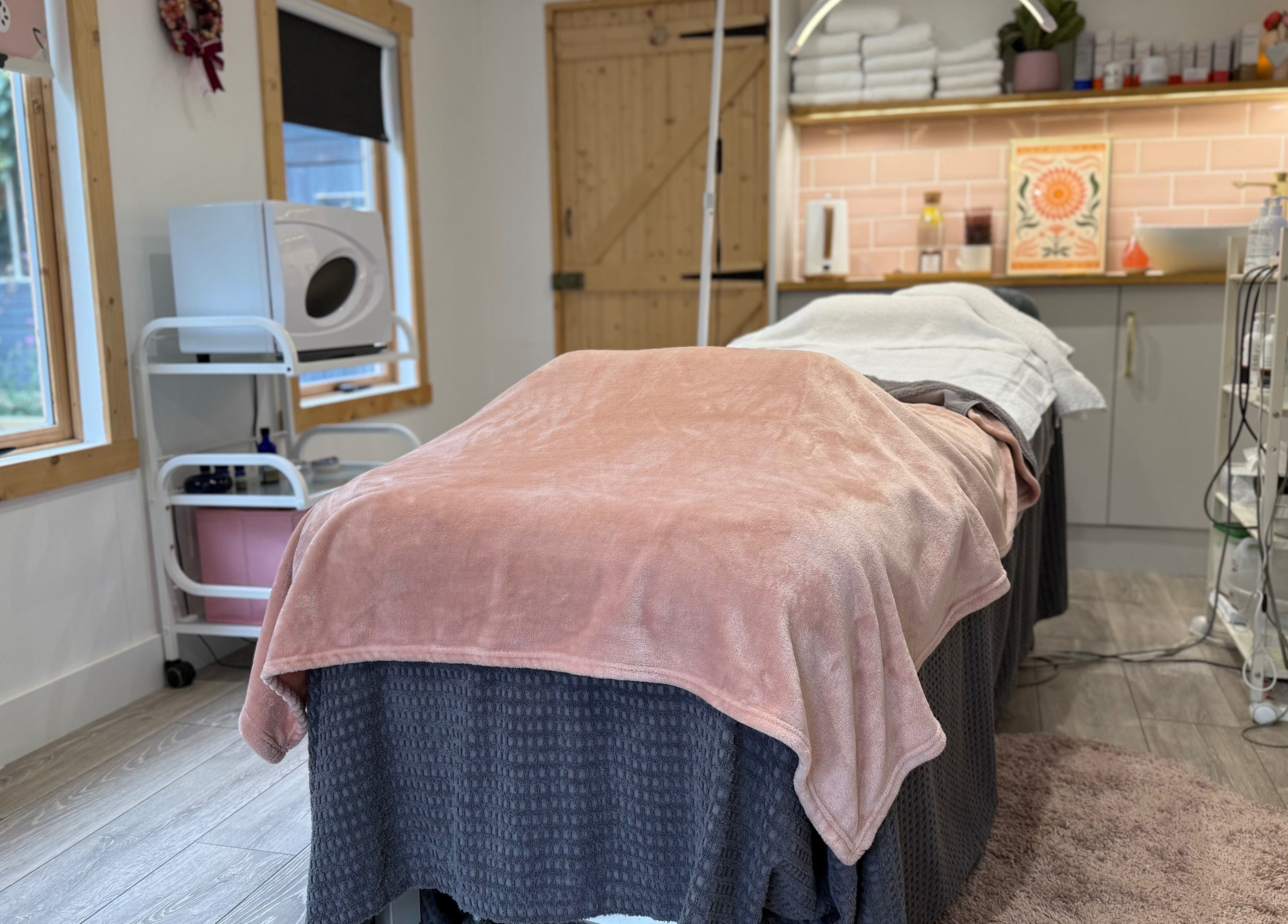 Relaxing treatment room at The Skin and Beauty Studio, Beaconsfield, England, GB with cozy blanket and soft lighting.