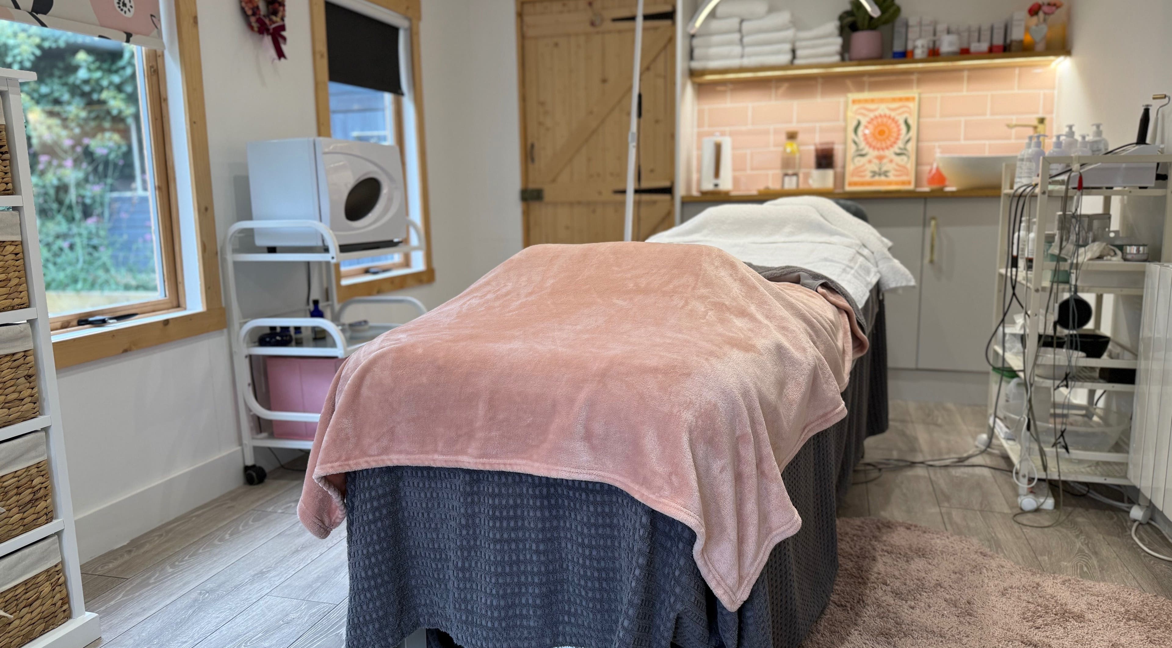 Relaxing treatment room at The Skin and Beauty Studio, Beaconsfield, England, GB with cozy blanket and soft lighting.