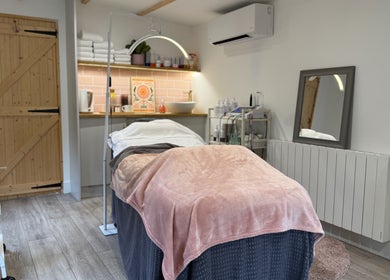 Cozy treatment room at The Skin and Beauty Studio, Beaconsfield, England, GB with soft linens and ambient lighting.