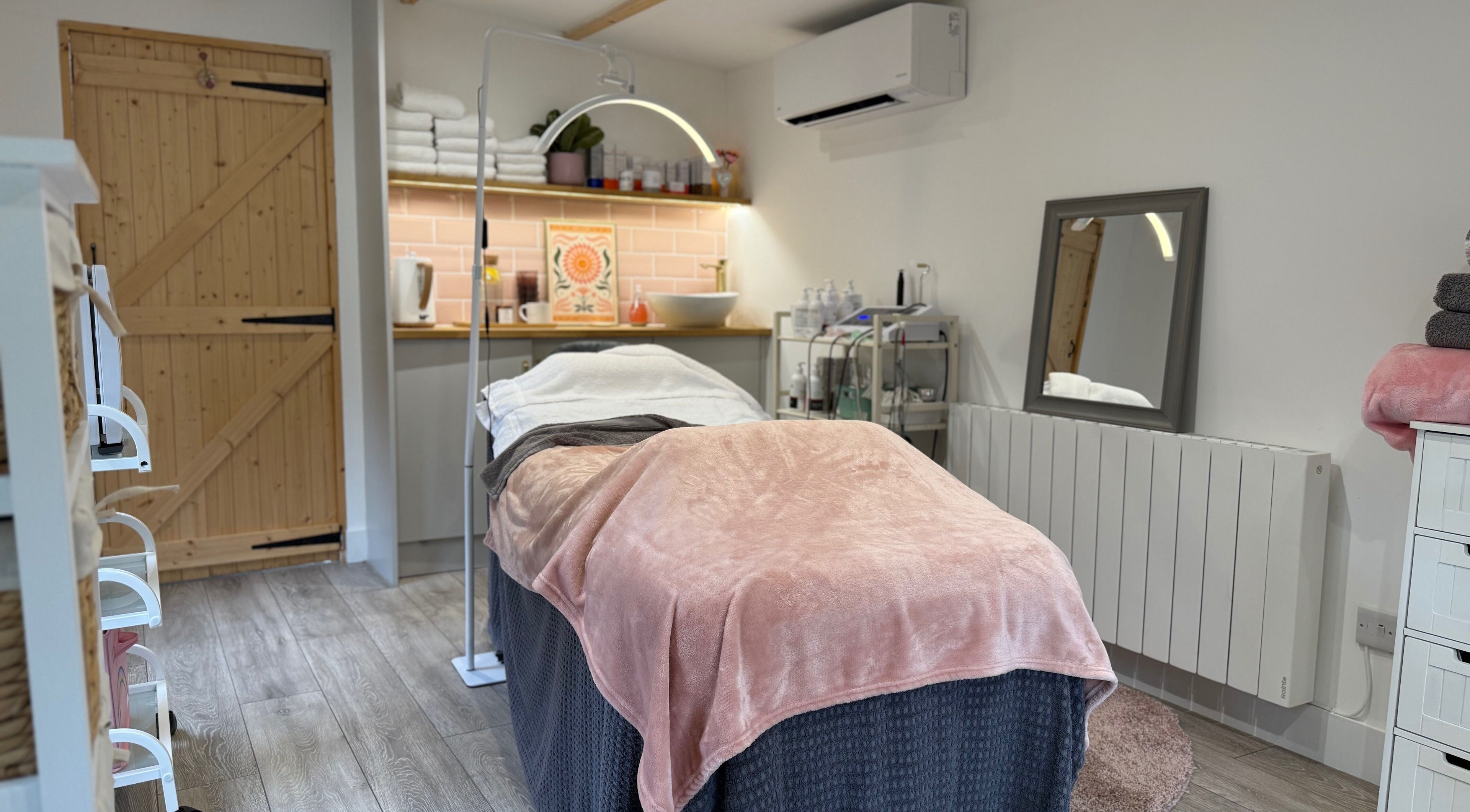 Cozy treatment room at The Skin and Beauty Studio, Beaconsfield, England, GB with soft linens and ambient lighting.