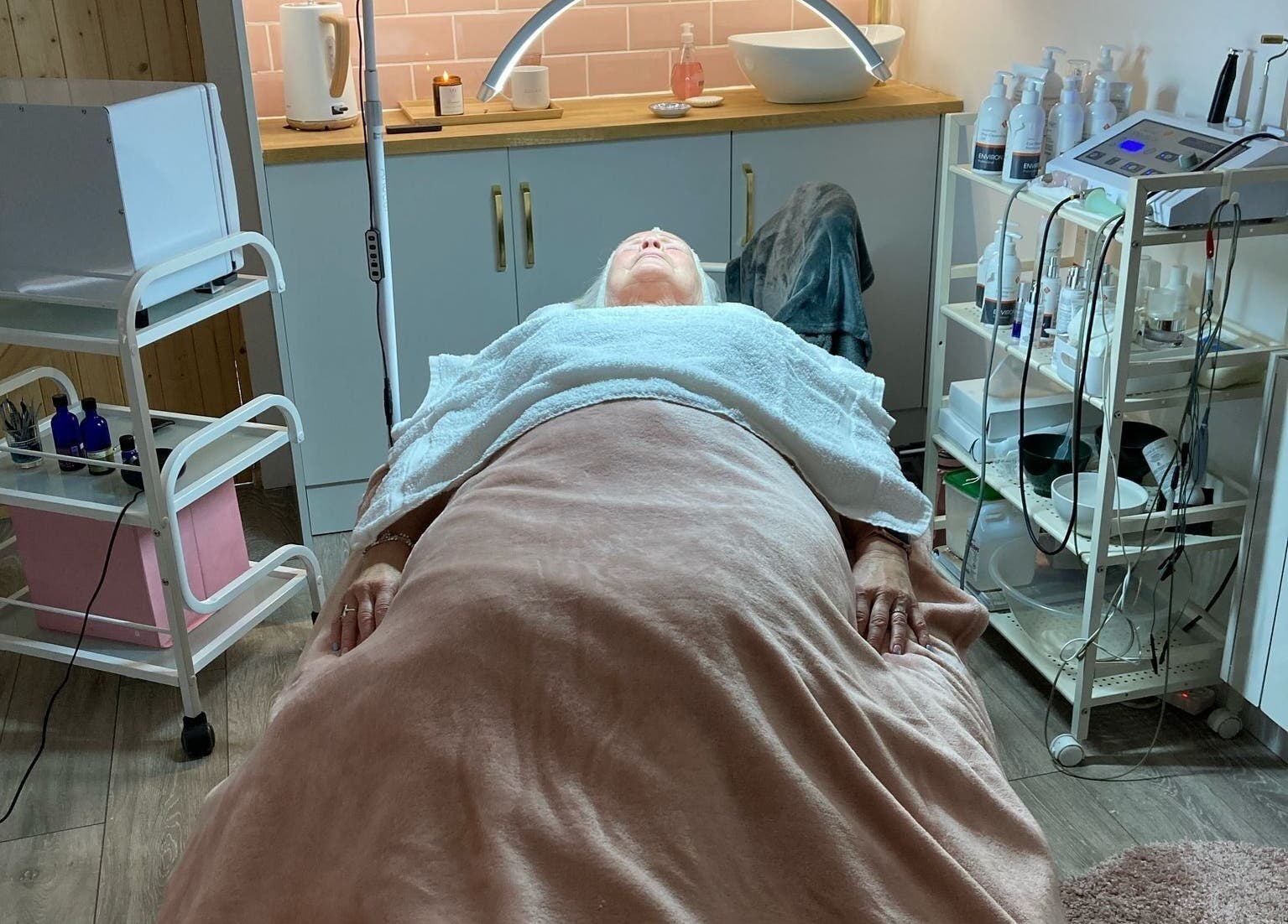 Client relaxing at The Skin and Beauty Studio, Beaconsfield, England, GB, during a soothing facial treatment.