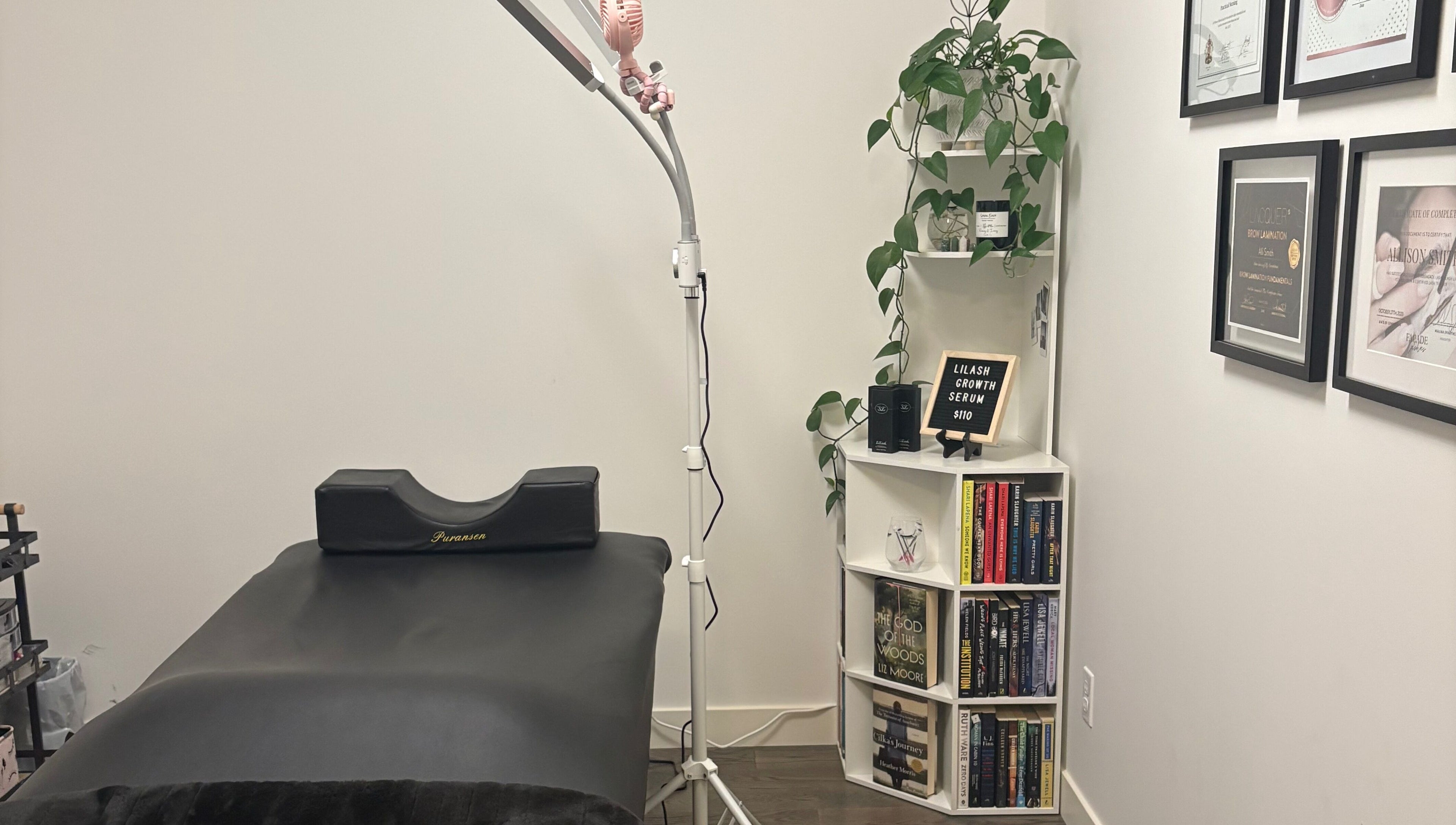 Treatment room at Lash Alley YYC in Calgary, Alberta, CA, featuring a bed, shelves, and lush decor.
