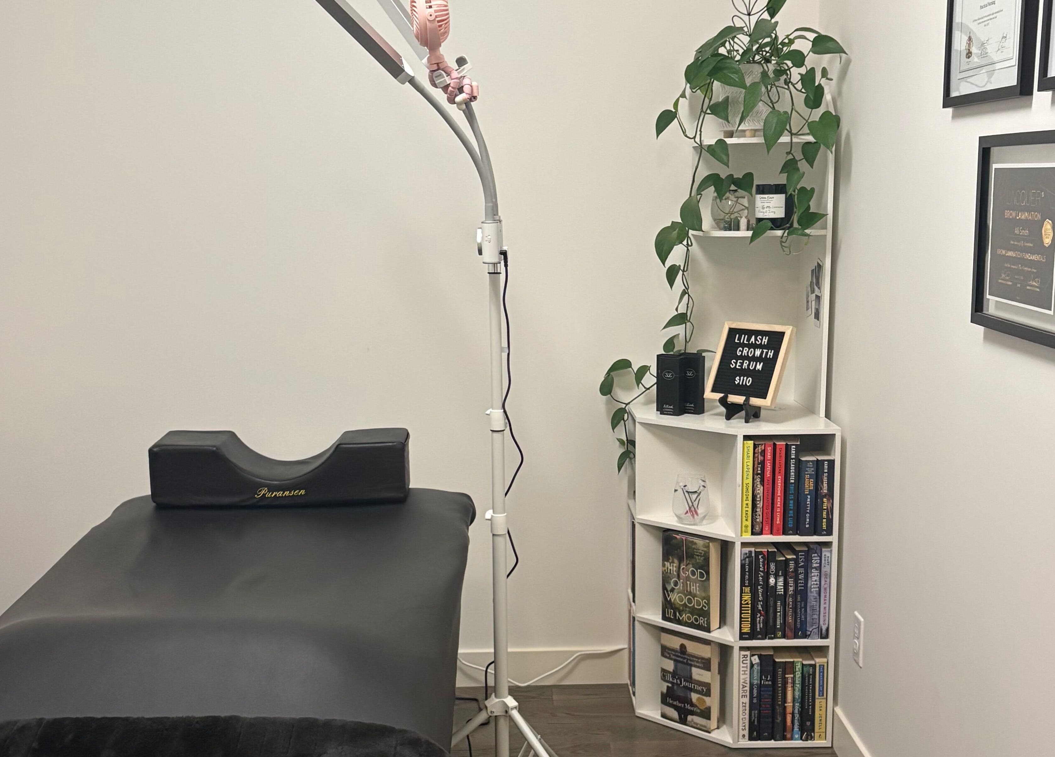 Treatment room at Lash Alley YYC in Calgary, Alberta, CA, featuring a bed, shelves, and lush decor.