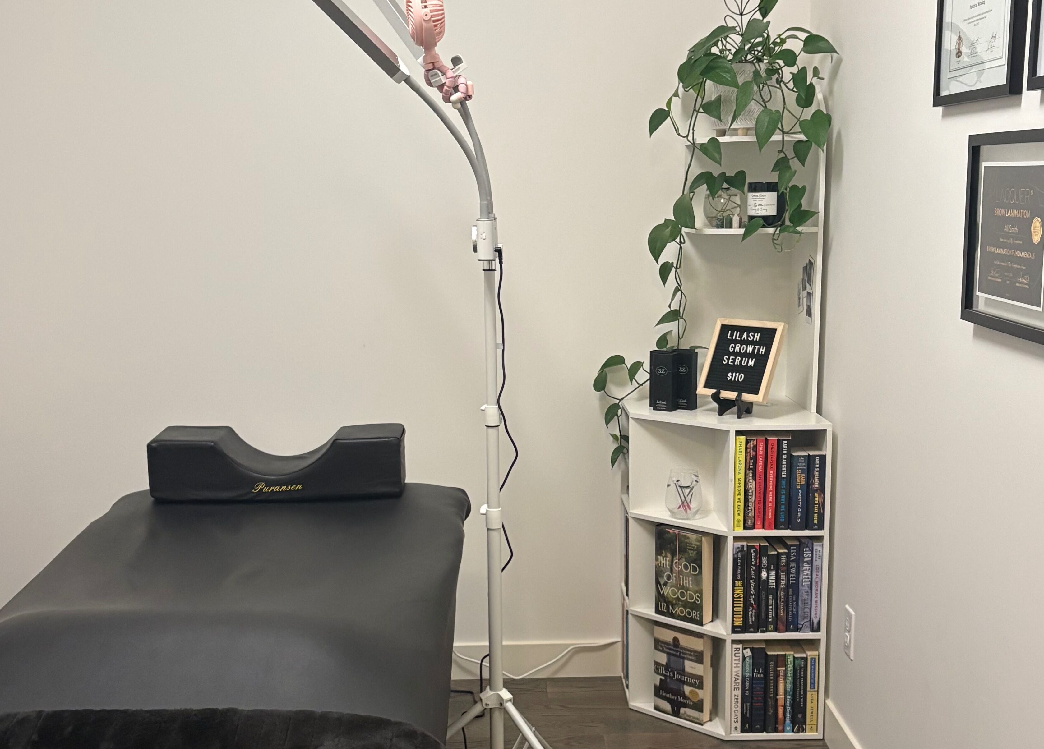 Treatment room at Lash Alley YYC in Calgary, Alberta, CA, featuring a bed, shelves, and lush decor.