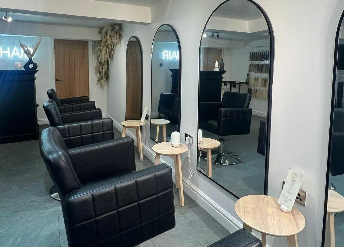 Modern salon interior at SW Hair Extensions, Watnall, England, GB with sleek black chairs and mirrors.