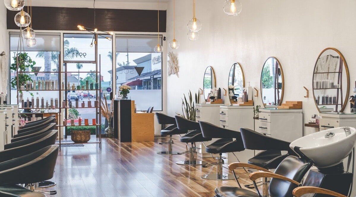 Interior of Del Sol Hair Studio in Huntington Beach, California, US, featuring stylish chairs and mirrors.