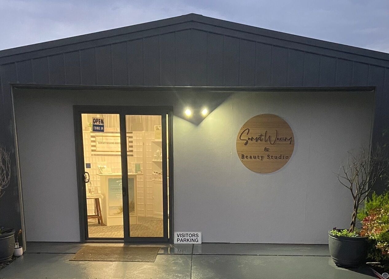 Entrance of Sunset Waxing Beauty Studio at dusk in Melbourne, Victoria, AU with sign and glass door.