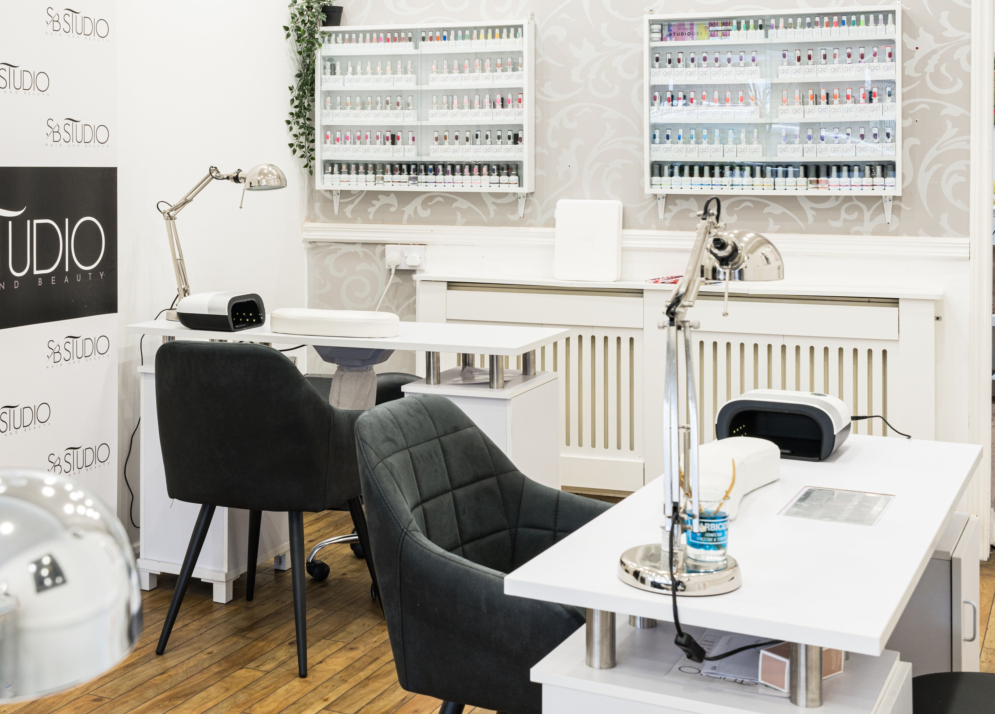Modern nail stations at SB Studio in Coulsdon, England GB showcasing sleek design and polish selection.