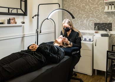 Aesthetician performs lash treatment at SB Studio in Coulsdon, England, GB in a serene, stylish space.