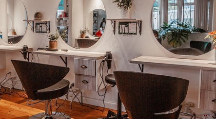 Cozy styling station at Citrine Hair Salon by Layla, Cape Town, Western Cape, ZA featuring modern chairs and mirrors.