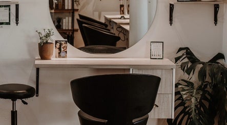 Stylish styling station at Citrine Hair Salon by Layla, Cape Town, Western Cape, ZA featuring a round mirror.