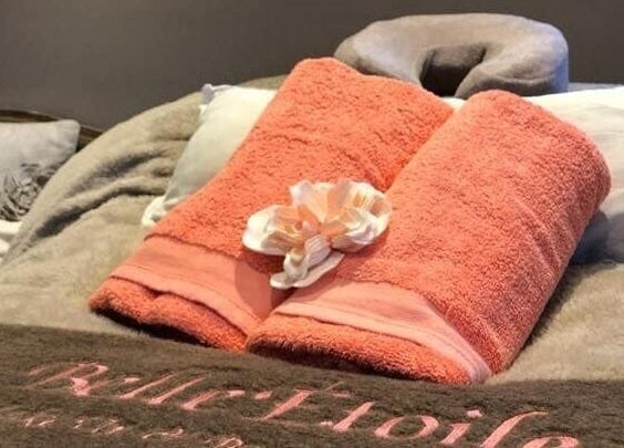 Belle Etoile Beauty massage table with plush towels and serene setting in Guernsey, GB.