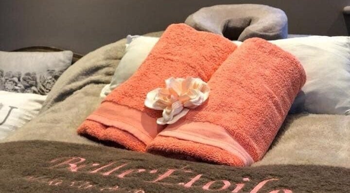 Belle Etoile Beauty massage table with plush towels and serene setting in Guernsey, GB.