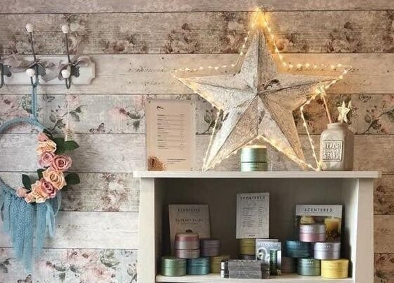 Chic decor at Belle Etoile Beauty in Guernsey, GB: floral wreath and star above display shelves.