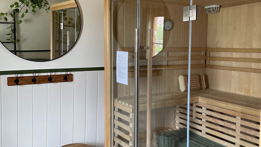 Interior of Sauna on the Corner, Middleton Beach, featuring wooden seating and modern glass door.