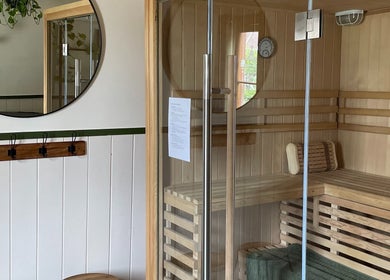 Interior of Sauna on the Corner, Middleton Beach, featuring wooden seating and modern glass door.