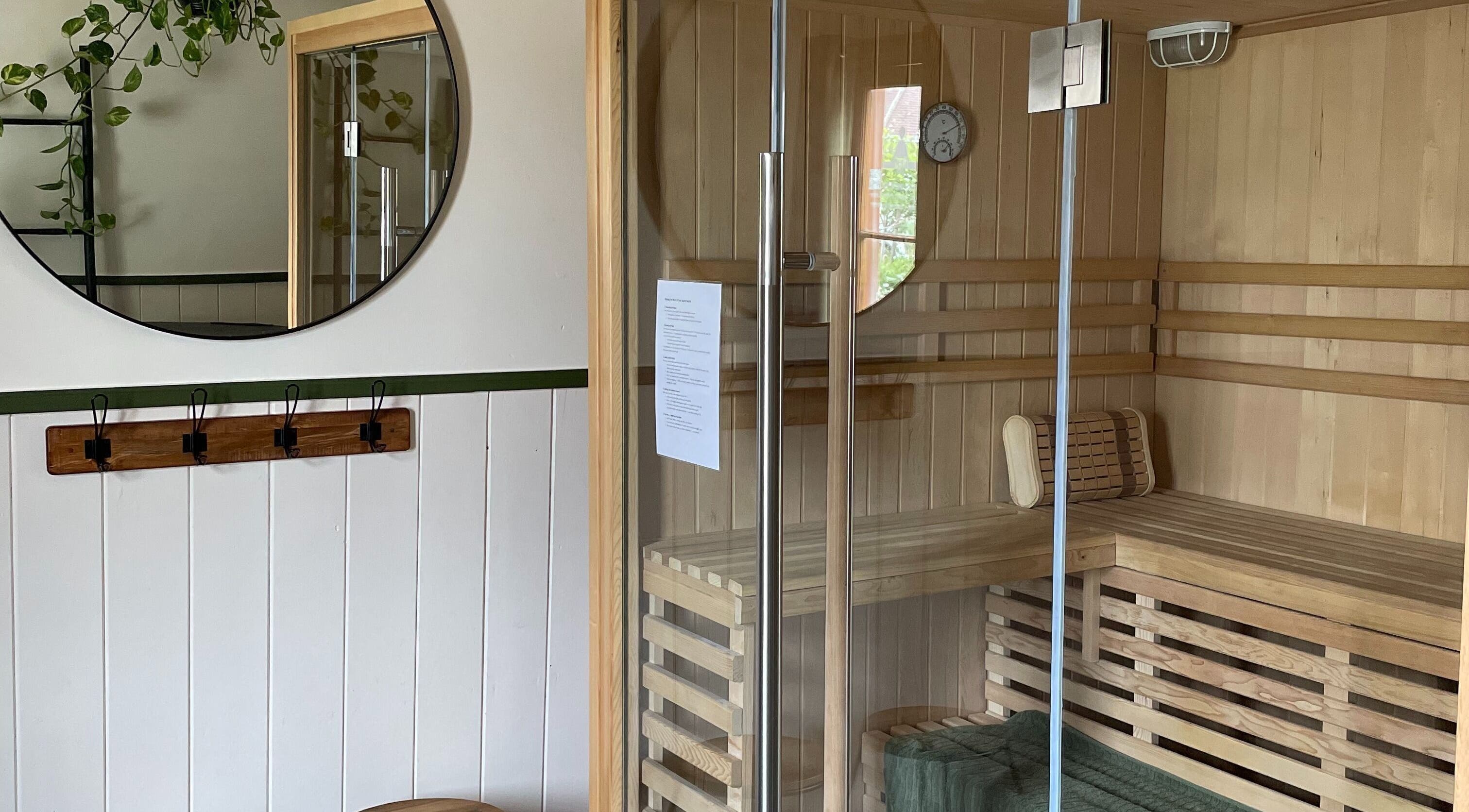 Interior of Sauna on the Corner, Middleton Beach, featuring wooden seating and modern glass door.