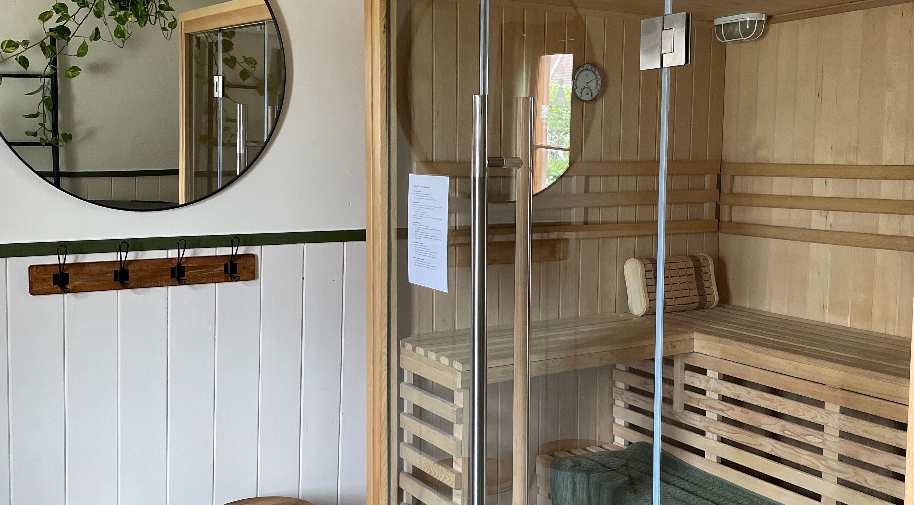 Interior of Sauna on the Corner, Middleton Beach, featuring wooden seating and modern glass door.