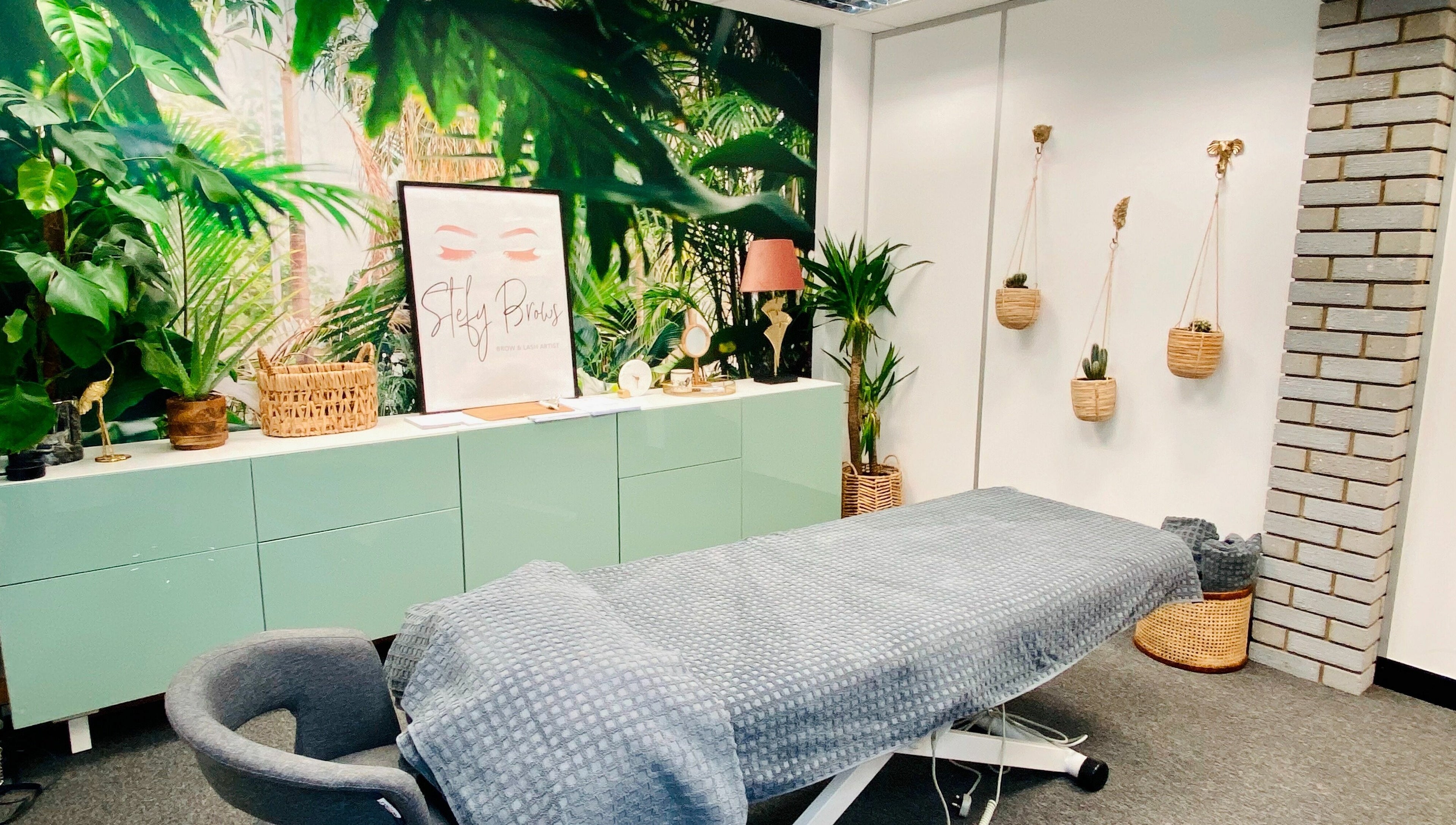 Relaxing treatment room at StefyBrows, Harpenden, England, GB with tropical decor and cozy ambiance.