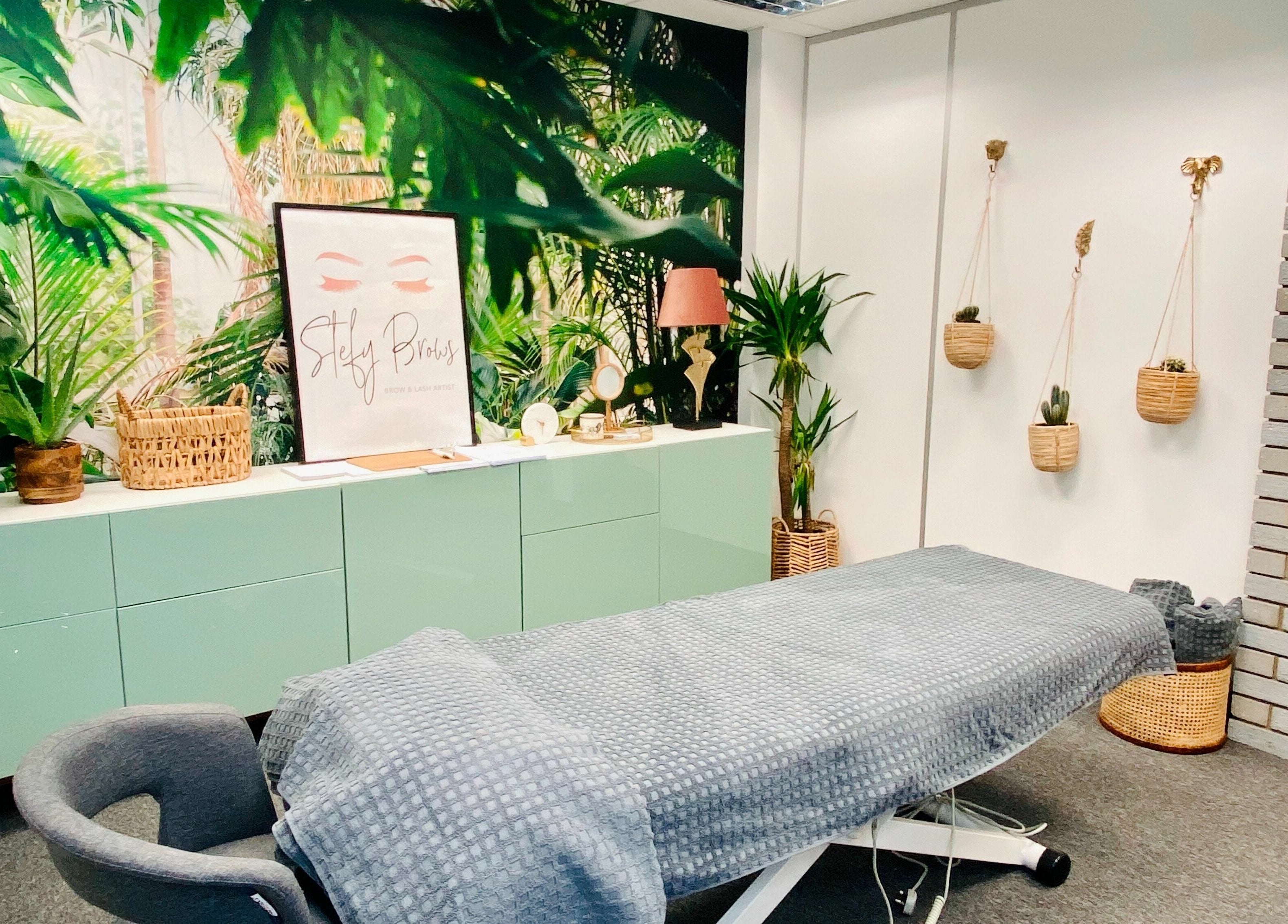 Relaxing treatment room at StefyBrows, Harpenden, England, GB with tropical decor and cozy ambiance.