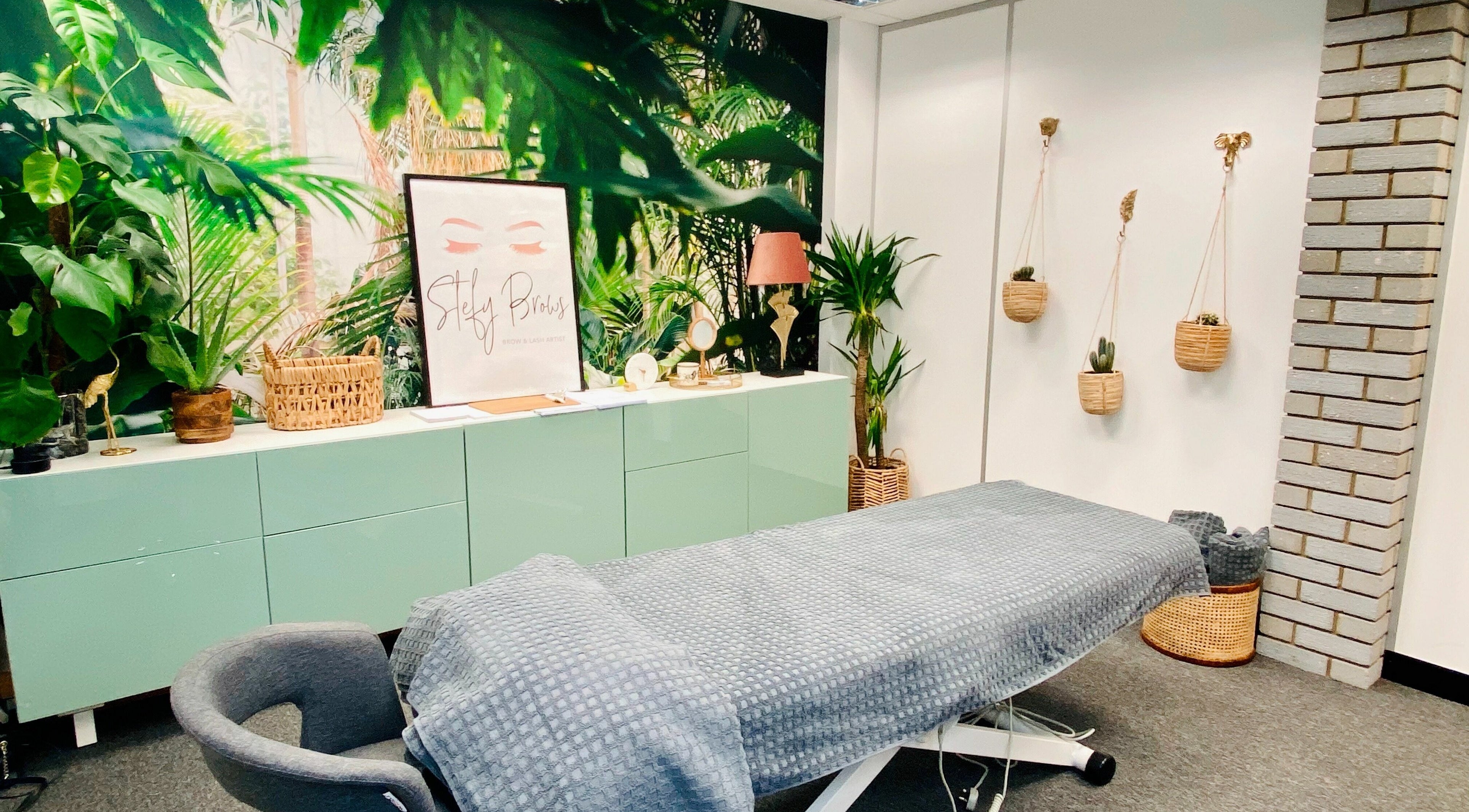 Relaxing treatment room at StefyBrows, Harpenden, England, GB with tropical decor and cozy ambiance.