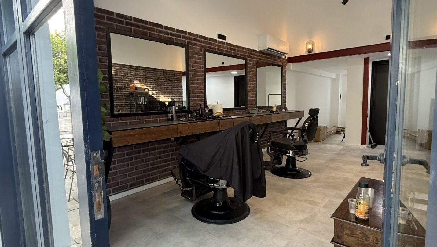 Modern interior of Panther Cuts, a chic barbershop in Pafos, Pafos, CY. Features sleek chairs and large mirrors.