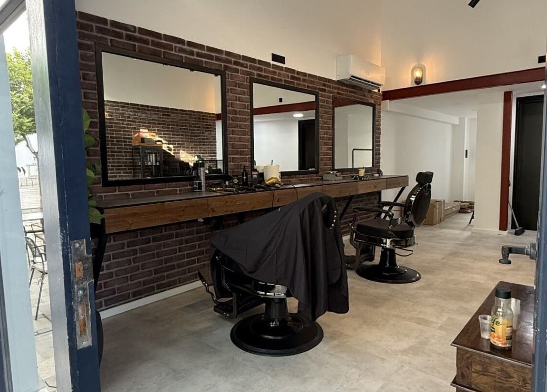 Modern interior of Panther Cuts, a chic barbershop in Pafos, Pafos, CY. Features sleek chairs and large mirrors.