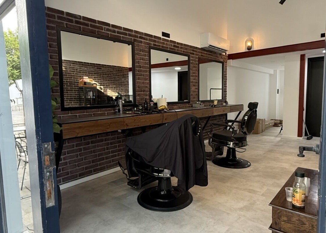 Modern interior of Panther Cuts, a chic barbershop in Pafos, Pafos, CY. Features sleek chairs and large mirrors.